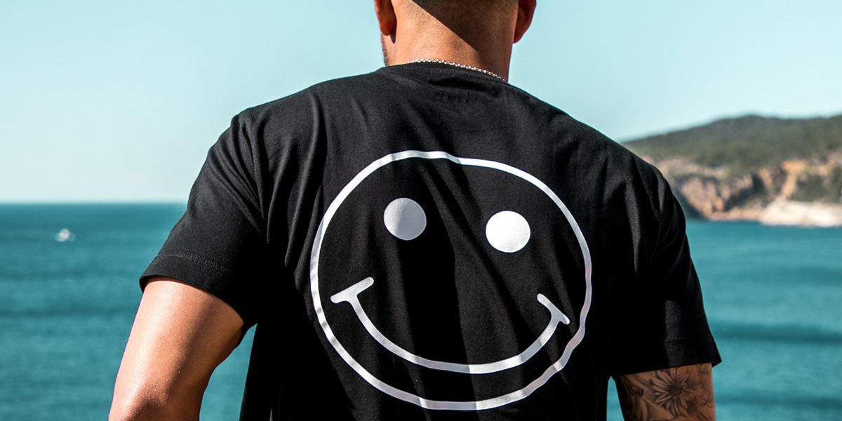 背面に白いスマイル柄のある黒いTシャツの着用写真